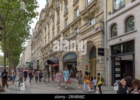 Massen von Einheimischen und Touristen auf der Avenue des Champs Elysees. Eine der berühmtesten Straßen der Welt für gehobene Luxus-Shopping. Paris, Frankreich. Stockfoto