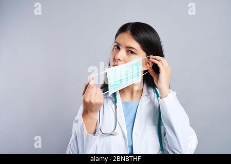 Asiatische Ärztin beginnt, eine Gesichtsmaske zu tragen Stockfoto