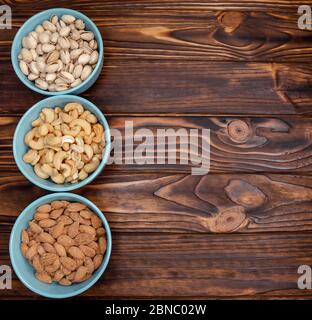 Verschiedene Arten von Nüssen in Schalen. Mandeln, Pistazien, Cashewkerne flach Stockfoto
