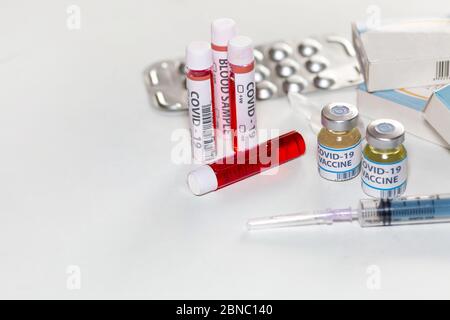 Impfstoffflaschen mit Injektionsspritze, Blutprobenflaschen und Medikamenten in einem Gesundheitszentrum für den Nachweis und die Behandlung von Coronavirus-Patienten Stockfoto