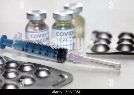 Injektionsspritze mit Impfstoffflaschen und Medikamenten in selektivem Fokus zur Behandlung von COVID-19 Coronavirus-Patienten Stockfoto