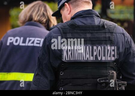 Dresden, Deutschland. Mai 2020. Zwei Polizisten von hinten mit der Aufschrift "Kriminalpolizei und Polizei" auf dem Rücken stehen verschoben am Tatort. Quelle: Tino Plunert/dpa-Zentralbild/ZB/dpa/Alamy Live News Stockfoto