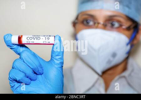 Krankenschwester hält eine Blutprobenflasche in einem indischen Testlabor für die Behandlung von Coronavirus Fällen Stockfoto