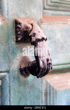 Nahaufnahme der vertikalen Aufnahme eines alten Türgriffs in der Form einer menschlichen Hand Stockfoto