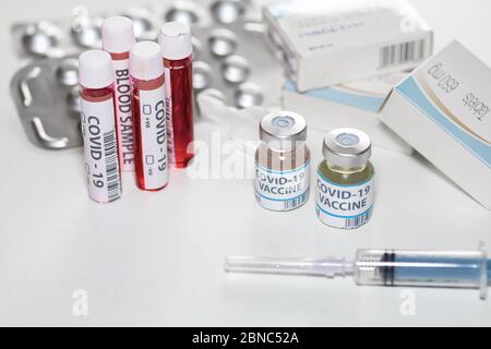 Impfstoffflaschen mit Injektionsspritze, Blutprobenflaschen und Medikamenten in einem Gesundheitszentrum für den Nachweis und die Behandlung von Coronavirus-Patienten Stockfoto