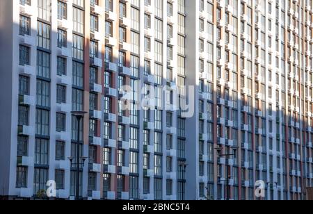 Muster aus den Fenstern eines neuen mehrstöckigen Gebäudes. Fenster in moderner Architektur. Mehrfamilienhaus, Neubau. Stockfoto