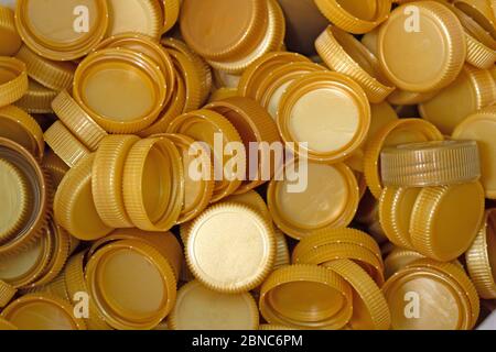 Der goldene Kunststoffdeckel, der von den Flaschen zurückgelassen wird, wird gesammelt, um in andere Gegenstände zur Wiederverwendung recycelt zu werden. Stockfoto