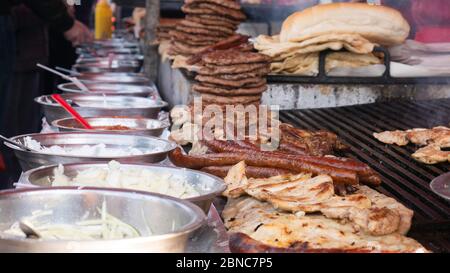 Grillen verschiedener Fleischsorten. Zubereitung von Burgern, Würstchen und Fleisch auf der Straße. Stockfoto