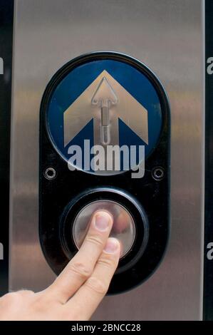 Finger drücken eine Ampel Taste in Brisbane. Dies kann als Konzepte für die Entscheidungsfindung, den Fortschritt oder die nächste Ebene verwendet werden Stockfoto