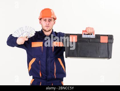 Mann mit Werkzeugkasten bekam Gehalt, Geld für Arbeit. Mechaniker mit strengem Gesicht in harter Hut auf weißem Hintergrund. Baumeister Geld verdienen, hält der Mechaniker Bargeld, Banknoten in der Hand. Zahltag-Konzept. Stockfoto