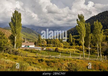 Altes Haus weiß im kleinen Dorf in den Karakol-Schluchtbergen in Kirgisistan Stockfoto