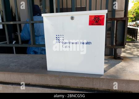 biohazard-Container vor dem Testgelände der covid-19 Community in Inwood für Coronavirus-Testproben, die von Northwell Health Labs verarbeitet werden Stockfoto