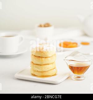 Gebratene Käsekuchen, süße Käsepfannkuchen auf weißem Teller auf weißem Hintergrund. Heimisch Tee Party Stockfoto