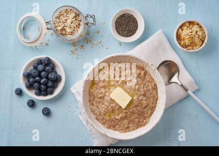 Haferflocken mit Butter und Belag. Heidelbeeren, Chia Samen, Mandelflocken. Draufsicht Stockfoto