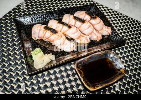 Medium Rare Rindfleisch Sushi auf einem schwarzen Teller ist bereit, in japanischem Stil zu servieren Stockfoto