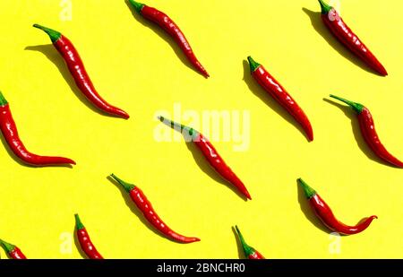 Rote Chilischoten Muster auf gelbem Hintergrund. Draufsicht. Paprika flach legen. Stockfoto