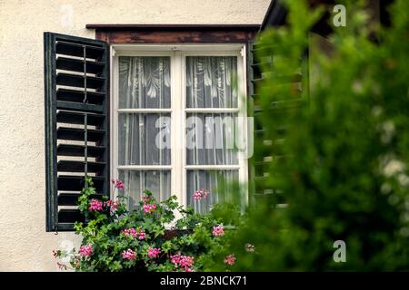 Öffnen Sie das Fenster an der Fassade eines weißen lokale Traditionelle alte Haus mit Blume im europäischen Stil in ländlich Dorf eingerichtet Stockfoto