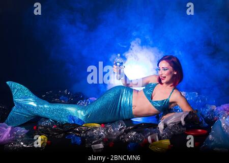 Fantasie dumme Meerjungfrau im tiefen Ozean. Plastikmüll und Flaschen Verschmutzung im Meer. Ökokatastrophe, Müll- und Kunststoffrecycling-Konzept. Stockfoto