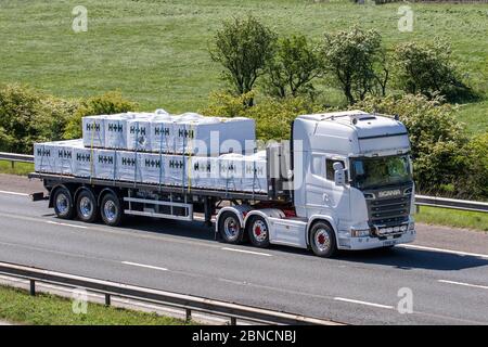 H+H Celcon Block Standard Grade Baumaterialien auf Flachbetttransportern; LKW, Transport, LKW, Frachtführer, Scania Vehicle, European Commercial Transport, Bauindustrie, M6 in Manchester, Großbritannien Stockfoto