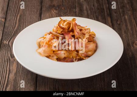 Gegrillte Schweineohren. In einer weißen Platte auf einem hölzernen Hintergrund. Stockfoto