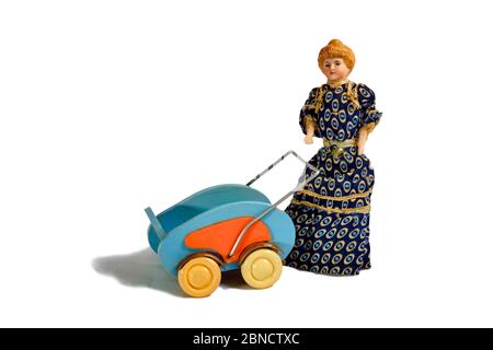 Historische Puppe in langem, dunklem Kleid mit Puppenwagen. Stockfoto