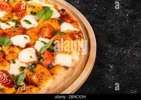 Pizza margarita auf schwarzem Steingrund. Stockfoto