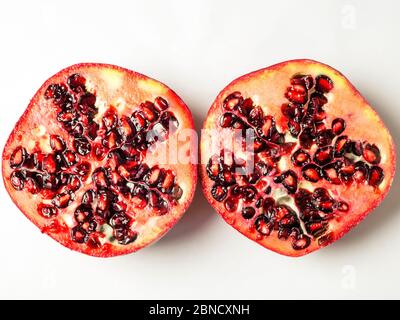 Frischer Granatapfel, in zwei Hälften geschnitten, isoliert auf weißem Hintergrund Stockfoto