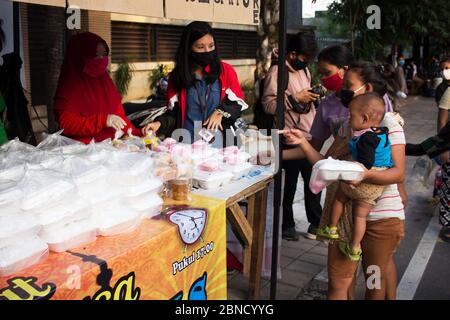 Jakarta, Indonesien. Mai 2020. Die Menschen warten in einer Schlange, um ihre Körpertemperatur und soziale Distanz Umsetzung, bevor sie in den heiligen Monat Ramadan in Jakarta, Indonesien, inmitten COVID-19 Coronavirus Krise zu brechen schnell erhalten. (Foto von Yogi Aroon Sidabariba/INA Photo Agency/Sipa USA) Quelle: SIPA USA/Alamy Live News Stockfoto