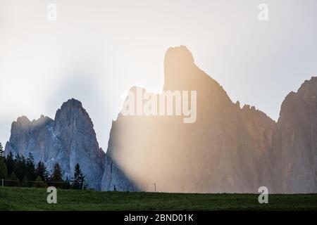 Herbst Geisler oder Geisler Dolomiten Berggruppe Felsen in contra Licht Sonnenschein Morgen trüb, Blick von Santa Magdalena berühmten Italien Dolomiten Dorf. Stockfoto