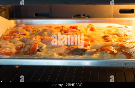 Frische Pizza wird im heißen Ofen zubereitet Stockfoto