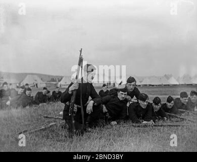 Vintage spätviktorianische Fotografien, aufgenommen 1903, zeigen Mitglieder der 2. Londoner Gewehre oder des 2. City of London Rifle Volunteer Corps. Es ist nicht sicher, ob diese Fotos in England oder Südafrika aufgenommen wurden, wo viele der Freiwilligen zu dieser Zeit ihren Sitz hatten. Foto zeigt eine Gruppe von Soldaten, die mit Gewehren trainiert werden, mit einer Reihe von Zeltplanen dahinter. Stockfoto