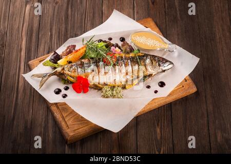 Gegrillte Makrele auf einem Holzbrett serviert. Stockfoto