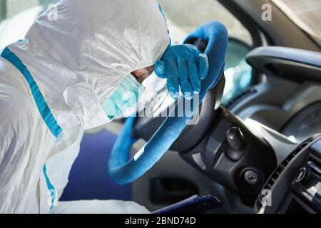 Müde Notarzt aus dem Rettungsdienst schläft am Lenkrad in der Ambulanz, während in Schutzkleidung vorbei Stockfoto