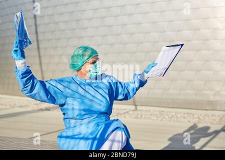 Containment Scout von der Gesundheitsabteilung für Coronavirus Kontaktverfolgung mit Liste und Schutzkleidung bietet einen Überblick Stockfoto