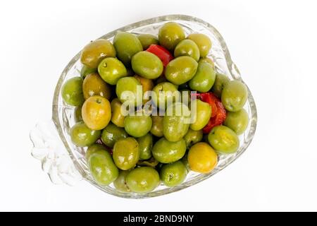 Marinierte Oliven in kleiner transparenter Schüssel. Auf weißem Hintergrund. Eingelegte grüne Oliven Stockfoto