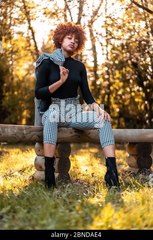 Lifestyle, afrohaarige Mädchen in einem karierten Anzug in einem Park fotografiert Stockfoto