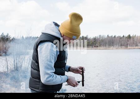 Mann, der draußen beim Camping Essen für ein bbq zubereitet Stockfoto