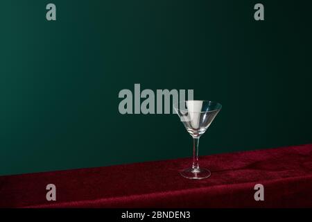 Hohe Winkelansicht des leeren Cocktailglases isoliert auf Grün Stockfoto