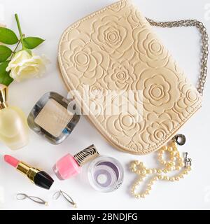 Kosmetik, Parfüms, Schmuck aus Perlen und Handtasche auf einem weißen Hintergrund. Flach, Ansicht von oben. Stockfoto