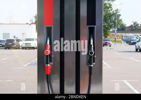 Schwarze und rote Kraftstoffpistolen an der Tankstelle. Benzin und Benzin Produkte Konzept. Pumpen von Benzin an der Benzinpumpe. Stockfoto