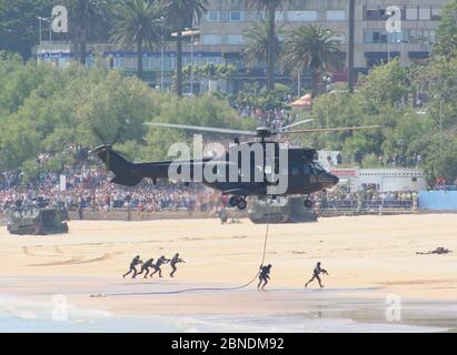 Serie 42 von 165 AAV-7A Amphibienfahrzeugen am Strand Und Soldaten abseilen von einem Eurocopter AS332B1 Super Puma während Tag Der Streitkräfte In Santander Stockfoto