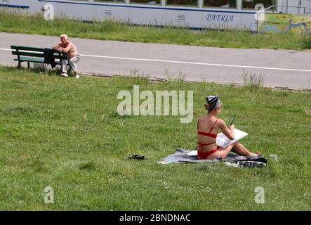 Krakau. Krakau. Polen. Junge Frau Künstlerin Malerei sitzen auf dem Gras, alter Mann beobachten. Stockfoto