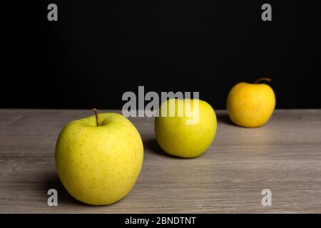 Reife Äpfel auf einem Holzbrett mit dunklem Hintergrund Stockfoto