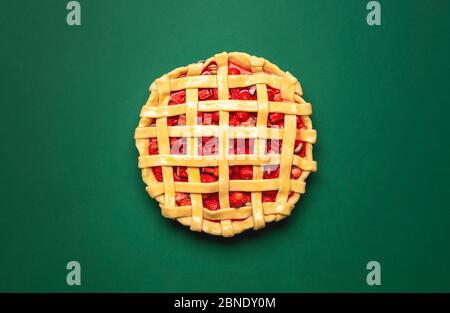 Erdbeeren und Rhabarber-Torte mit Gitterkruste, Blick über dem Bild auf grünem Hintergrund. Draufsicht mit einem Gitterkruste Fruitcake. Stockfoto