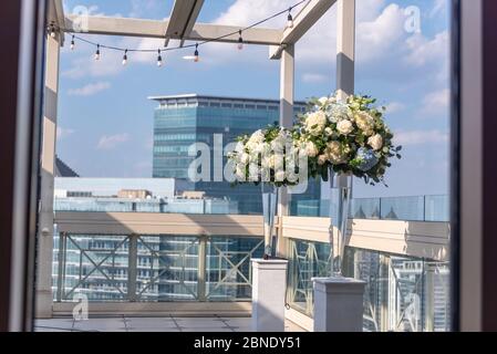 Zwei Vasen mit schönen Blumen auf denen Säulen auf der Dach eines Gebäudes Stockfoto