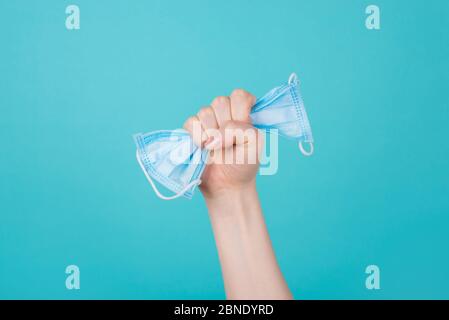 Gesundheitskonzept. Foto von Frau, die eine Maske in der Faust hält, die in der Luft aufrast, isoliert auf blauem Hintergrund Stockfoto