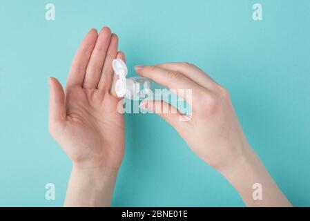 Halten Hände sauber Konzept. Oben oben oben Ansicht von oben beschnitten Foto von Frau mit Handdesinfektionsmittel isoliert auf türkisfarbenem Hintergrund Stockfoto