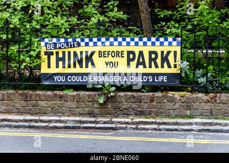 Ein Banner auf dem Geländer vor einer Schule mit der Aufschrift "Think Before You Park", auf dem Autofahrer gebeten werden, höflich zu sein und vorsichtig zu parken, Nord-London, Großbritannien Stockfoto