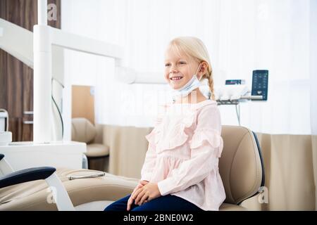 Eine zufriedene kleine Zahnarztpatientin, die ihr perfektes Lächeln zeigt Zahnärztliche Behandlung in einer Klinik Stockfoto