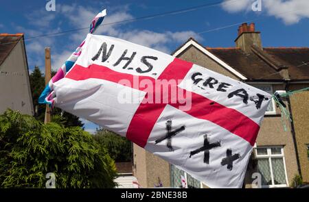 Eine englische Flagge, die vor einem Suburban-Haus in Südwestlondon mit den Worten, NHS-Great, und drei X, Küsse fliegt. Stockfoto